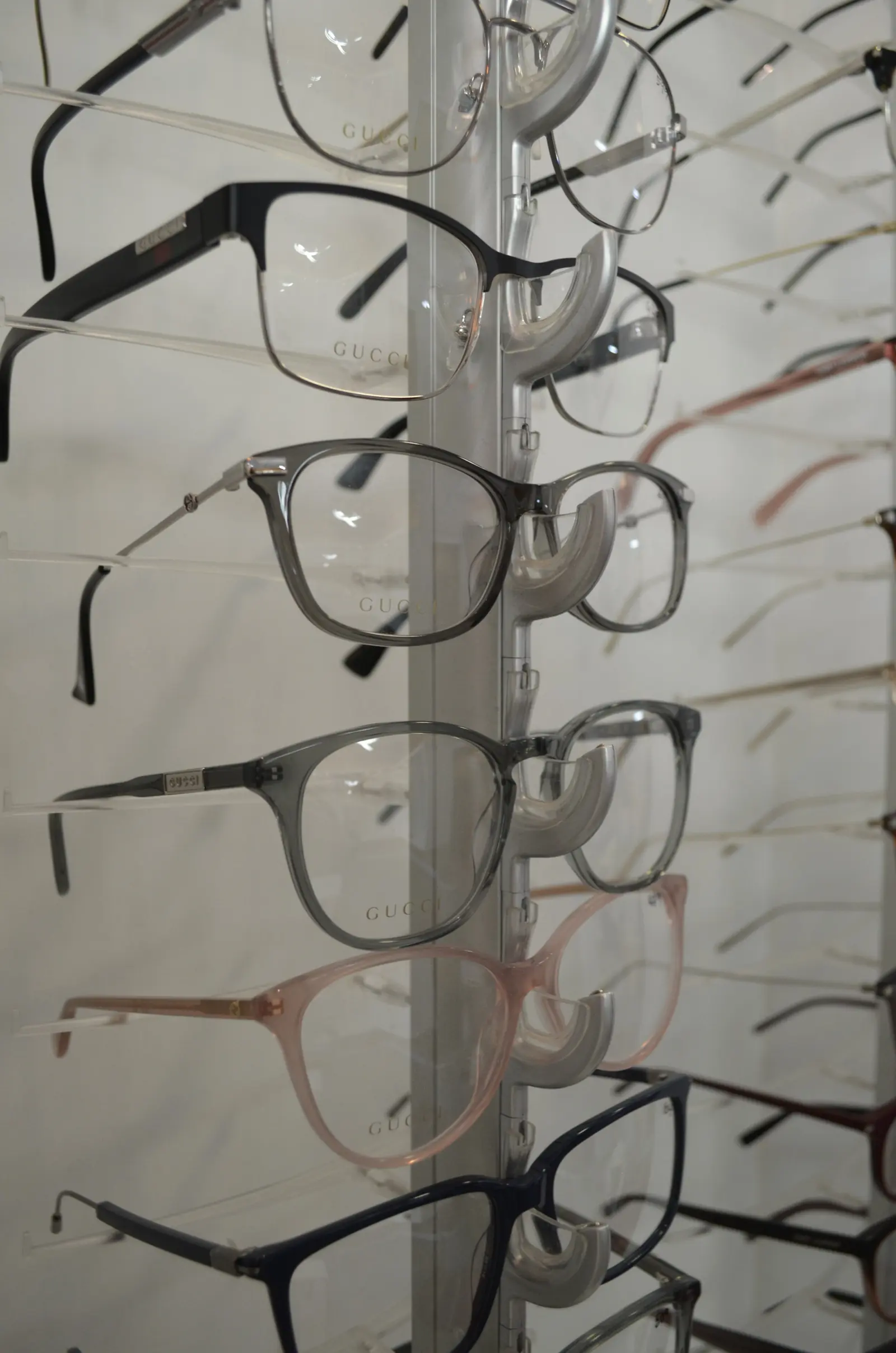 Rows of glasses frames on lit display rods in The EyeSite optical